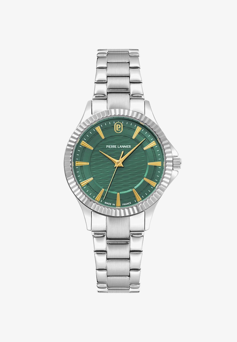 Reloj de hombre con un dial texturizado verde, correa de acero inoxidable plateada, marcadores de hora dorados y un bisel de plata estriado. Logo de la marca visible.