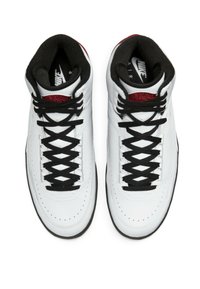 Vita hög-top sneakers i läder med svarta snören och detaljer, med en vadderad krage och en röd logo på tungan.