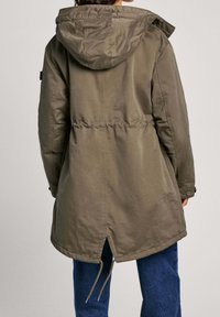 Olivewą zieloną parkę z kapturem, elastycznym pasem i rozcięciem z tyłu. Wykonana z fakturowanej tkaniny z zatrzaskami jako akcentami.