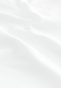 Tissu blanc et lisse avec une texture douce, présentant de légères ondulations et un éclat subtil, suggérant légèreté et fluidité.