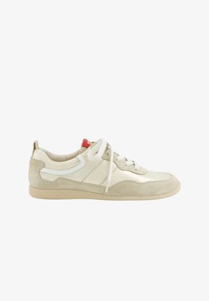 Sneaker in suede e pelle beige con lacci bianchi, suola in gomma e linguetta rossa su sfondo bianco.