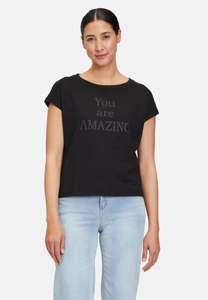 T-shirt noir en coton à coupe décontractée, manches courtes et encolure ronde. Présente le texte "Vous êtes INCROYABLE" dans une police en gras.