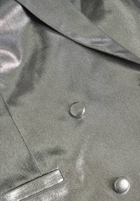 Metalni sivi dvoredni sako s teksturiranom završnom obradom, koji ima glatke rever i okrugle dugmadi.