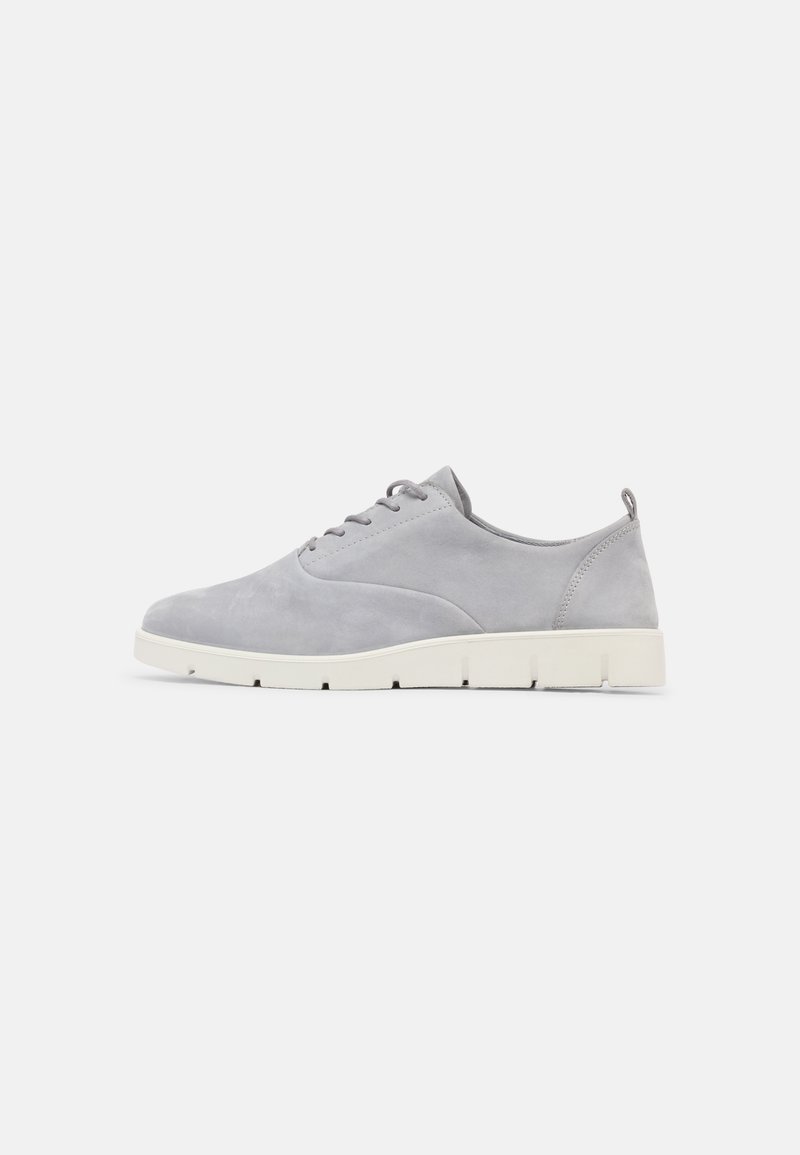 Scarpe in suede grigio con profilo basso, dotate di una suola in gomma bianca, lacci rotondi e un design minimalista. Nessun motivo o accento visibile.