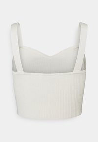 Witte geribde bralette met brede bandjes en een gestructureerde, ronde halslijn. De stof is glad met een subtiele textuur.