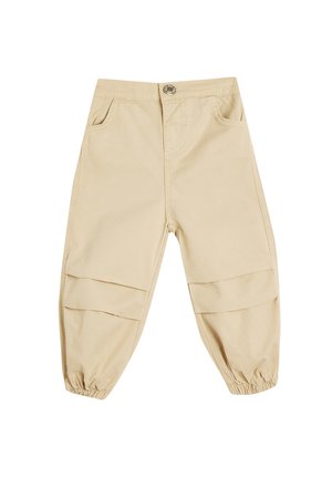 Beige bomuldsbukser med en afslappet pasform, der har elastiske cuffs, to frontlommer og vandrette patchwork-detaljer på benene.