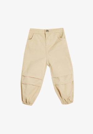 Pantalones de algodón beige con un corte relajado, que cuentan con puños elásticos, dos bolsillos frontales y acentos de patchwork horizontal en las piernas.