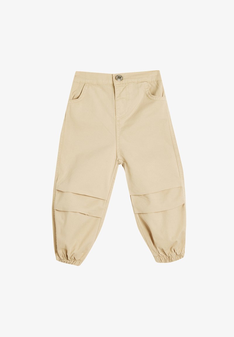 Beige bomuldsbukser med en afslappet pasform, der har elastiske cuffs, to frontlommer og vandrette patchwork-detaljer på benene.