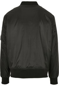 Chaqueta bomber negra con una tela lisa y brillante. Presenta un cuello, puños y cintura de canalé. Diseño simple sin adornos visibles.