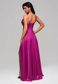 Fuchsia satin kvällsklänning med en åtsittande liv, spaghettiband, öppen rygg och sidslits, med en flödande kjol.