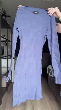 Vestido de manga longa canelado em roxo claro. Apresenta um decote redondo e uma barra ligeiramente curva. Feito de um tecido macio e elástico.