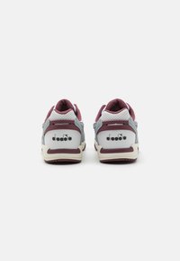 Retro sneakers med grå mocka, hvite lærpaneler, burgunder detaljer og perforerte detaljer. Har en gummisåle og merkevare på hælen.