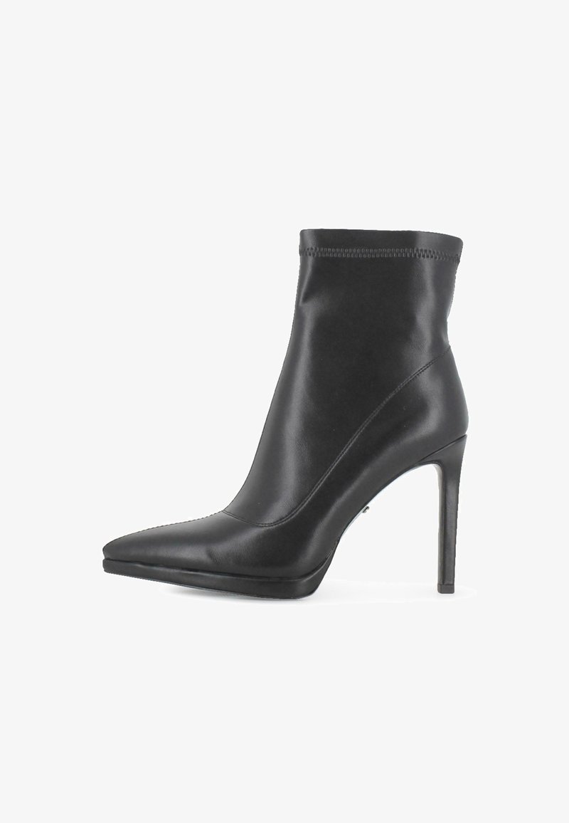 Botín de cuero negro hasta el tobillo con punta afilada y tacón de aguja delgado y alto, parte superior lisa y ribete cosido en el borde superior.