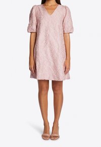 Sukienka z krótkim rękawem w kształcie V w jasnoróżowym kolorze z teksturowanym wzorem kwiatowym. Dopasowana góra, rozkloszowany dół i gładki materiał. Prosty, do kolan projekt.