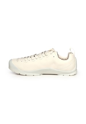 Baskets basses en cuir blanc cassé avec laçage à l'avant, bout arrondi et languette au talon, montrées de profil sur fond blanc.