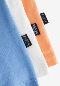 Trys medvilniniai marškinėliai, mėlynos, baltos ir oranžinės spalvų, su mažais tamsiais etiketėmis "BAKER by Ted Baker" ant kaklo.