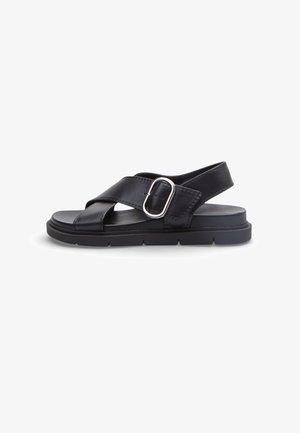 Sandalo in pelle nera con ampie cinghie incrociate, fibbia argentata, suola spessa e cinturino posteriore per una calzata sicura, mostrato in vista laterale.