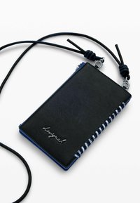 Svart läderplånbok med blå detaljer, försedd med dragkedjestängning och dekorativ sömnad längs ena kanten. Inkluderar ett avtagbart band.