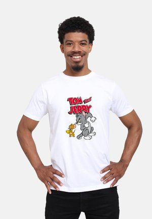 Hvid bomulds T-shirt med en farverig grafik af Tom og Jerry, med fed tekst i rød. Korte ærmer og et klassisk crew neck design.