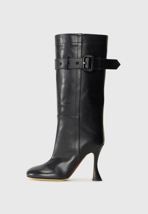 Sort læderstøvle med høje hæle i en spidset form, der har en detalje med en sidebuckle og en glat overflade. Inkluderer et spidst tådesign.