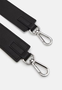 Bracelet en cuir noir avec une surface texturée, doté de fermoirs et de pièces de fixation en métal argenté à chaque extrémité.