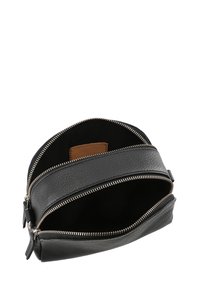 Borsa in pelle nera con una finitura texturizzata e zip argentate. Caratterizzata da un'apertura superiore e un'etichetta interna in pelle marrone. Design compatto.