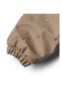 Beige stof med en glat tekstur, der har små, trykte motiver af forskellige objekter. Elastisk manchet detaljer giver en sikker pasform.