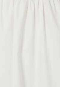 Jupe en tissu blanc avec taille élastique froncée, texture lisse et plis verticaux subtils.