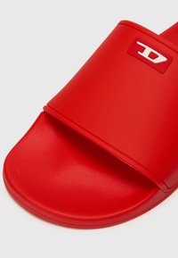 Sandală roșie cu talpă lată și branț texturat. Prezintă un logo alb pe brant, realizată dintr-un material sintetic neted.