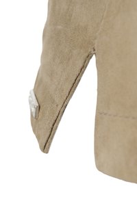Hellbraune Wildlederjacke mit strukturiertem Finish, sauberem Saum und einem silbernen Hardware-Akzent an der linken Ärmel.