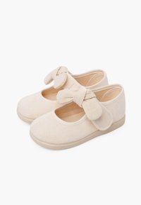 Beige Leinenschuhe für Ballett mit runden Zehen, einer Schleifendetails am Riemen und einer flexiblen Gummisohle. Geschmeidige Textur durchgehend.