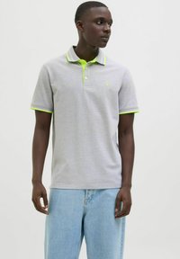 Graues kurzärmliges Poloshirt mit einem gelb-grünen Kragen und Akzenten an den Ärmeln; verfügt über eine Knopfleiste mit drei Knöpfen und ein kleines Logo auf der Brust.