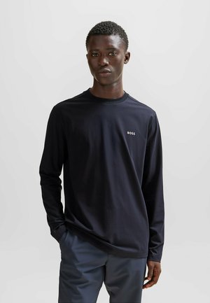 Zwarte T-shirt met lange mouwen en een ronde hals, met een witte "BOSS" logo op de linkerborst. Gemaakt van een gladde, lichte stof.