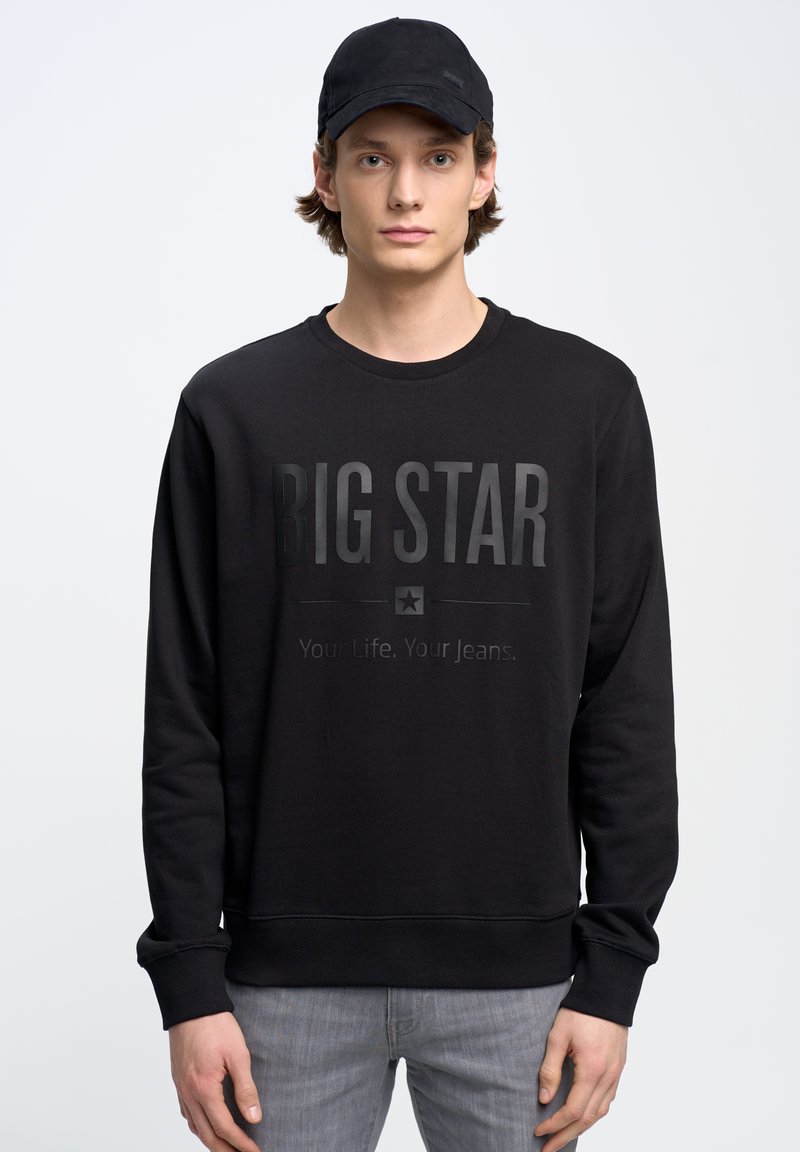 Juodas džemperis su apvalia iškirpte, ilgomis rankovėmis ir tekstūruotu audiniu. Puošiamas iškilniu "BIG STAR" logotipu ir išryškintu tekstu žemiau.