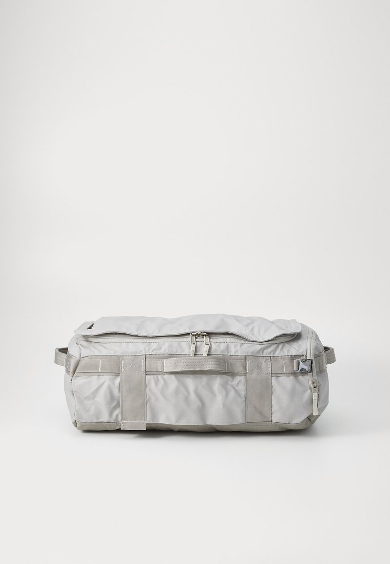 Saco de duffel cinza, feito de tecido durável, com parte superior zippada, alças acolchoadas e correias reforçadas para suporte. Textura suave e mate.