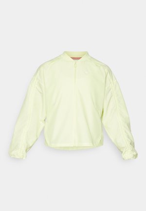 Light yellow zip-up jacket with a high collar, oversized sleeves, and elastic cuffs. Features subtle branding on the chest and smooth texture.