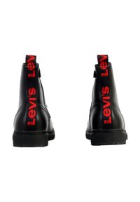 Zwarte leren enkelboots met een rood "Levi's" logo op de treklus, ronde neus en stevige rubberen zool. Heeft een rits aan de zijkant.