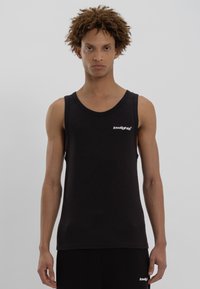 Sort tanktop lavet af bomuld med ribbet tekstur. Har en rund halsudskæring og et lille hvidt logo på venstre bryst.