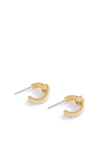 Złote kolczyki w kształcie kół z zakrzywionym wzorem, posiadające gładkie metalowe wykończenie i srebrny klips. Minimalistyczne z eleganckim akcentem.