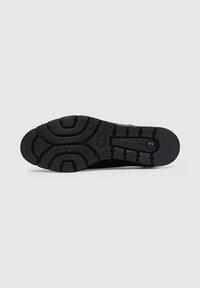 Suela de zapatilla atlética negra con un patrón de banda de rodadura de goma texturizada, que presenta nodos de agarre variados y un borde suave para estabilidad.