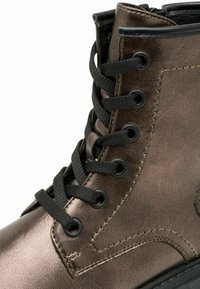 Bota de tobillo de cuero marrón con cordones negros, acabado metálico texturizado, herrajes con ojales y costuras en negro contrastantes a lo largo de las costuras.