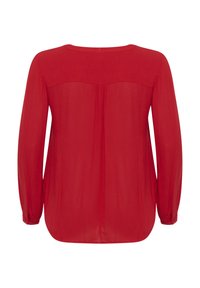 Blusa rossa a maniche lunghe con scollo rotondo, in tessuto morbido, e dettaglio plissettato sul retro. Accentuata da polsini arrotondati.