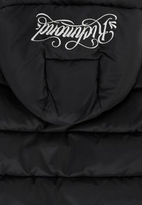 Giacca puffer nera con colletto alto, motivo trapuntato orizzontale e logo rovesciato bianco. Texture morbida e liscia.