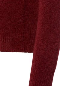 Bordeaux gebreide trui met een zachte, fuzzy textuur. Voorzien van ribgebreide manchetten en zoom, lange mouwen en een ontspannen pasvorm.