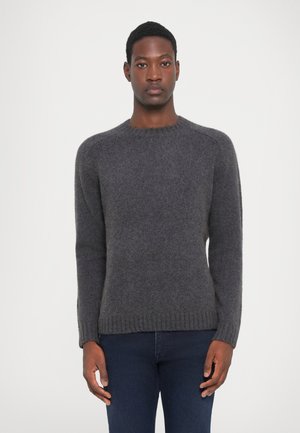 Grå, strikket sweater med lange ærmer, en rund halsudskæring og ribbet kant. Stoffet ser blødt ud med en let fuzzy tekstur.