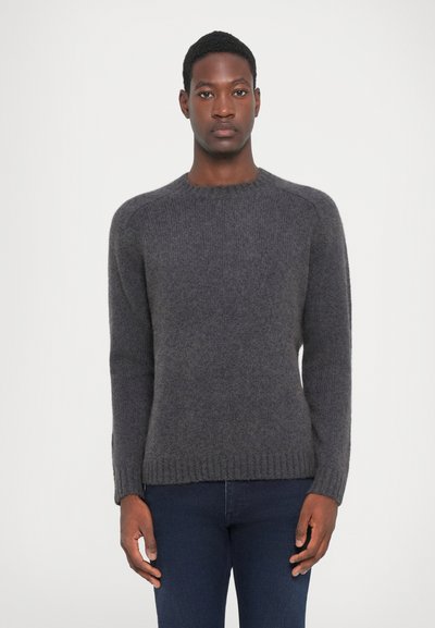 Grå, strikket sweater med lange ærmer, en rund halsudskæring og ribbet kant. Stoffet ser blødt ud med en let fuzzy tekstur.