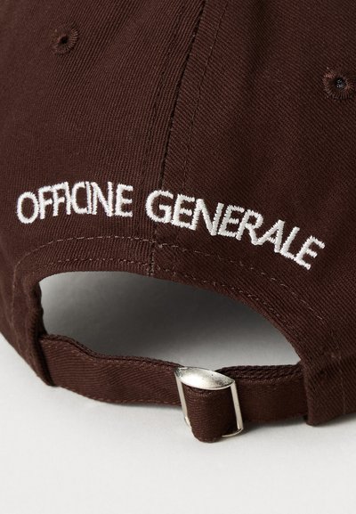 Donkerbruine stoffen pet met witte geborduurde tekst "OFFICINE GENERALE" en een verstelbare metalen gesp aan de achterkant.
