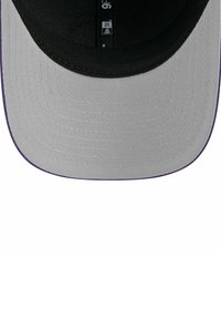 Cappello grigio con visiera piatta e accento viola lungo il bordo. Il tessuto ha una consistenza liscia con cuciture visibili.