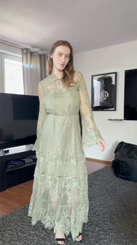 Rochie lungă, stratificată, din dantelă verde deschis, transparentă, cu mâneci clopot și modele florale. Dispune de un corp ajustat și detalii cu lembă la gât.