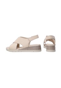 Beige wedge sandals with a cross-strap design, open toe, and back strap. Textured sole with light brown striped accents.